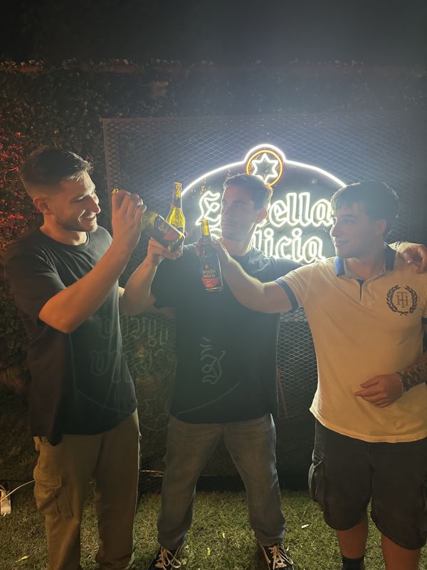 Brindis con Estrella Galicia frente al cartel de neón